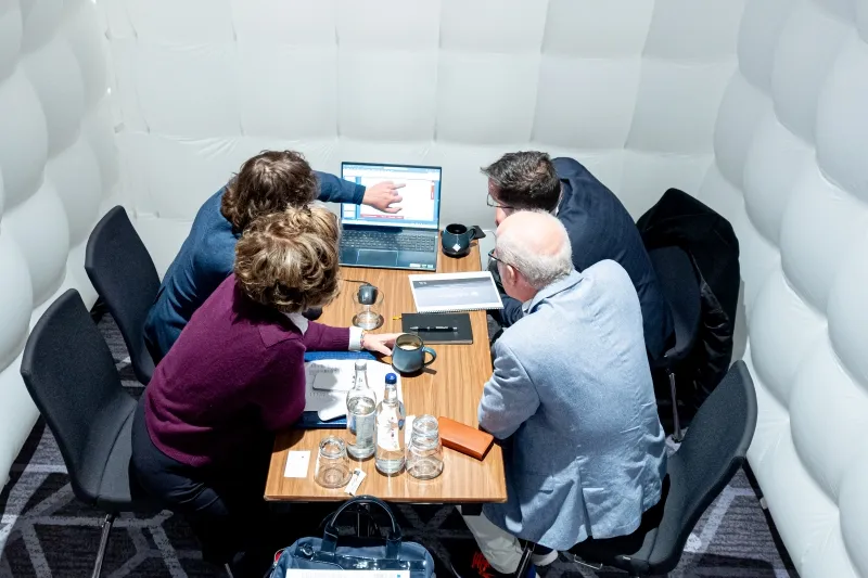 Close-up of mining professionals discussing project documents at a meeting